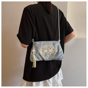 Detail der blauen chinesischen Sticktasche mit Goldblumen und weißen Quasten