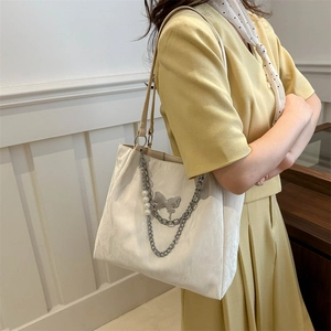 White ruched tote bag with silver chain and butterfly charms for versatile daily commuting