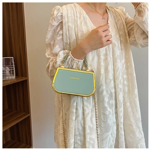 Detail of mint green leather box clutch with gold metal frame and fashion logo