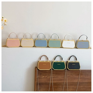 Macro shot of macaron-colored crossbody bags with gold metal hardware and chain straps