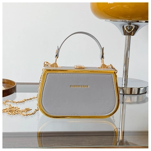 Detail of grey chain box handbag with gold trim and Fashion & Bag lettering on PU leather