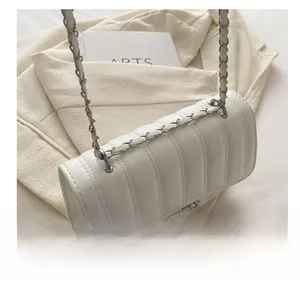 Detail of white quilted handbag with silver chain strap and rhinestone metal buckle