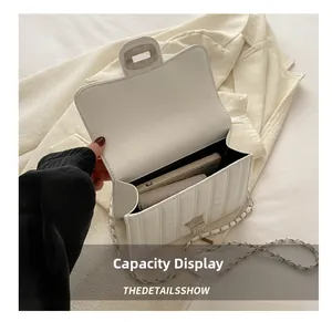 Interior view showing the capacity of a white pleated crossbody bag for phone and wallet