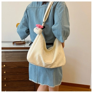 Detail view of cream soft leather hobo bag with cute sheep charm and adjustable strap