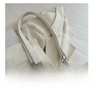 Detail of white woven texture leather tote bag featuring silver metal chain shoulder strap