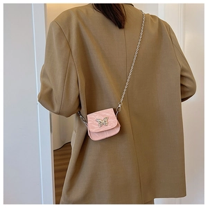 Détail du mini sac bandoulière rose avec fermoir papillon en métal et bandoulière chaîne