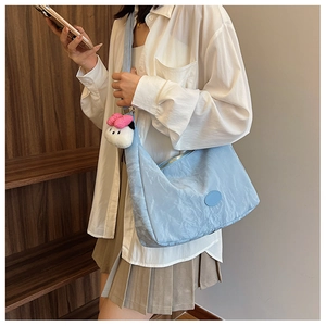 Light blue crossbody bag with soft textured fabric and a cute white plush pendant