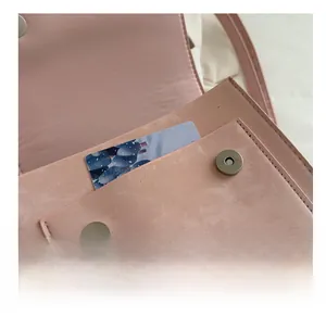 Vista detallada del bolsillo frontal del bolso rosa con cierre magnético y costura fina