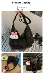 Detail of black crescent shoulder bag with crinkled texture and plush doll charm