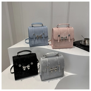 Detalle de mini mochilas mate de varios colores con elegantes lazos metálicos plateados