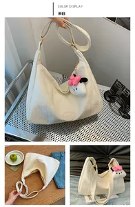 Detail of off-white pleated shoulder bag with cute plush pendant and adjustable wide strap