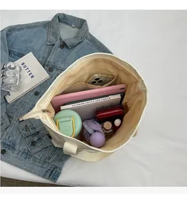 Top view of white canvas tote bag showing large interior space filled with daily essentials