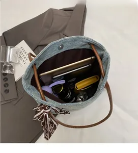 Interno spazioso della borsa tote in denim con tablet, telefono e dettaglio foulard