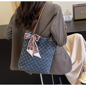 Dettaglio della borsa tote in denim con motivo trapuntato bianco e foulard decorativo in seta