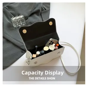 Interior view of white crossbody bag showing capacity for phone and cosmetics