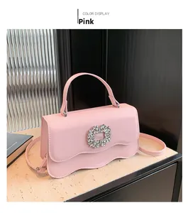 Detail of pink crossbody bag with scalloped edges and sparkling rhinestone buckle