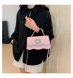 Detail of pink small square bag with sparkling crystal buckle and wavy flap design