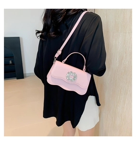 Detail of pink wave-edge crossbody bag with a large sparkling rhinestone buckle