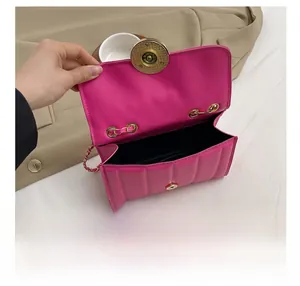 Interior view of small pink quilted crossbody bag with golden hardware and black lining