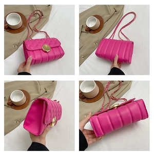 Detail view of pink quilted leather crossbody bag with gold metal lock and chain strap