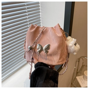 Pink drawstring bucket bag with silver butterfly metal ornament and white plush charm