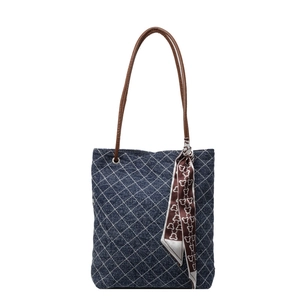 Borsa tote in denim trapuntato con manici in pelle marrone e foulard su sfondo bianco