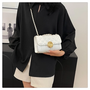 Close-up of white quilted mini square bag with gold metal chain strap and turn-lock