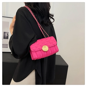 Detail of rose pink quilted crossbody bag with gold twist lock and woven chain strap