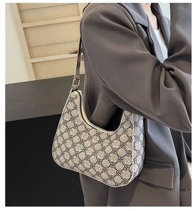 Close-up of vintage hobo bag with blue floral pattern styled with a grey blazer