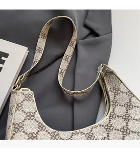 Close-up of retro crescent moon bag featuring brown clover patterns and durable PU handle
