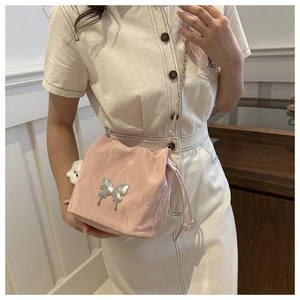 Detail of pink satin bucket bag featuring silver butterfly buckle and plush charm