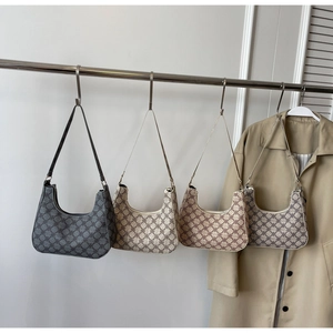 Detail of four retro crescent hobo bags in assorted monogram colors on a display