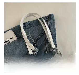 Dettaglio della borsa tote in pelle bianca con catena argentata e cuciture raffinate
