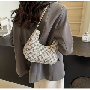 Detailed view of a vintage printed crescent hobo bag worn on the shoulder by a model