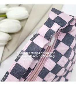 Dettaglio della borsa trapuntata a scacchi rosa con connettore per tracolla e zip