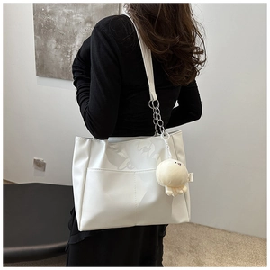 Dettaglio borsa shopper in pelle bianca con catena argento e ciondolo a polpo