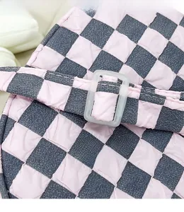 Dettaglio del tessuto a scacchi rosa e grigio con trama a bolle e fibbia in resina