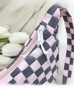 Dettaglio della cerniera in metallo e del motivo a scacchi sulla borsa rosa