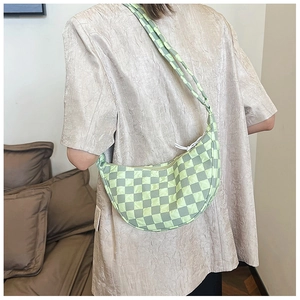 Dettaglio della borsa hobo a scacchi verde chiaro indossata da una modella con tracolla