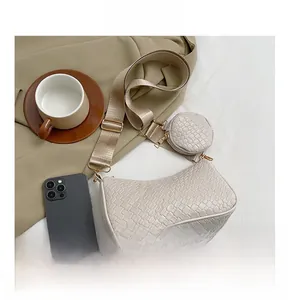 Vue détaillée du sac à bandoulière tressé blanc cassé avec pochette ronde et téléphone mobile