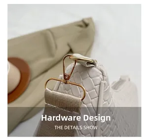 Détail du sac bandoulière en cuir tressé avec boucle dorée et sangle en tissu