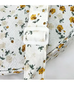 Detail of floral canvas bag showing adjustable shoulder strap and smooth plastic buckle