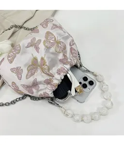 Detail of satin drawstring bag with butterfly embroidery showing spacious interior