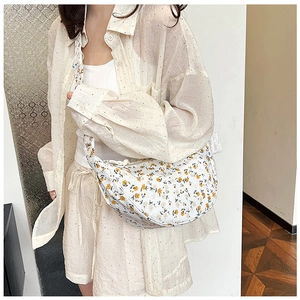 Floral canvas half-moon crossbody bag with vibrant yellow flowers and wide shoulder strap