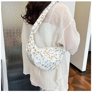 Detailed view of yellow floral canvas dumpling bag with shoulder knot and wavy texture