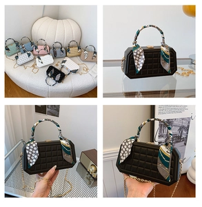 Detail of square lattice quilted box bag with silk scarf handle and gold chain strap