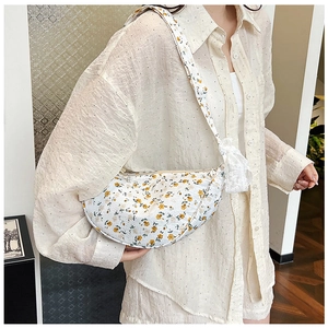 Detailed shot of floral canvas crossbody bag featuring white lace bow and yellow pattern