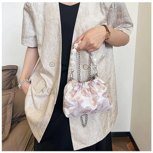 Detail of white satin bucket bag with pink butterfly embroidery and large pearl handle