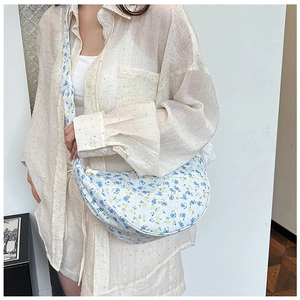 Detailed macro view of floral print canvas crescent bag with crossbody strap for women