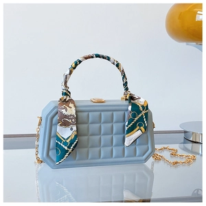 Detail of light blue box handbag with lattice quilting and floral silk scarf handle